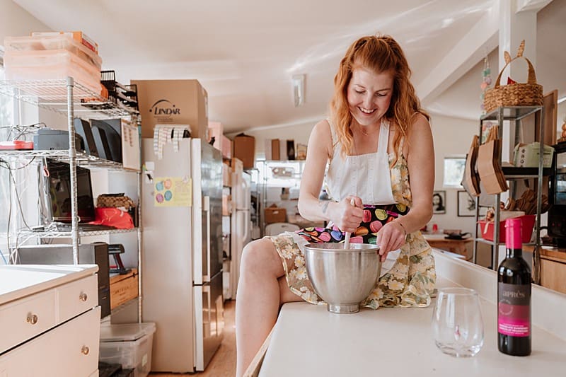 Entrepreneur smiling while working in a bright creative space — personal branding portrait showing authenticity and warmth.